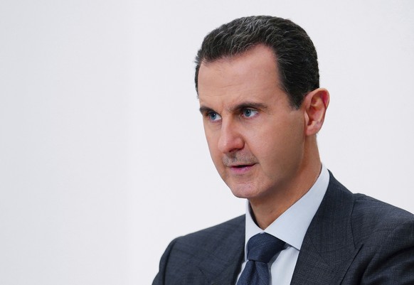 FILE - In this photo released on November 9, 2019 by Syria's official news agency SANA, Syrian President Bashar Assad speaks in Damascus, Syria.  Guards from the Syrian president's Baathist police...