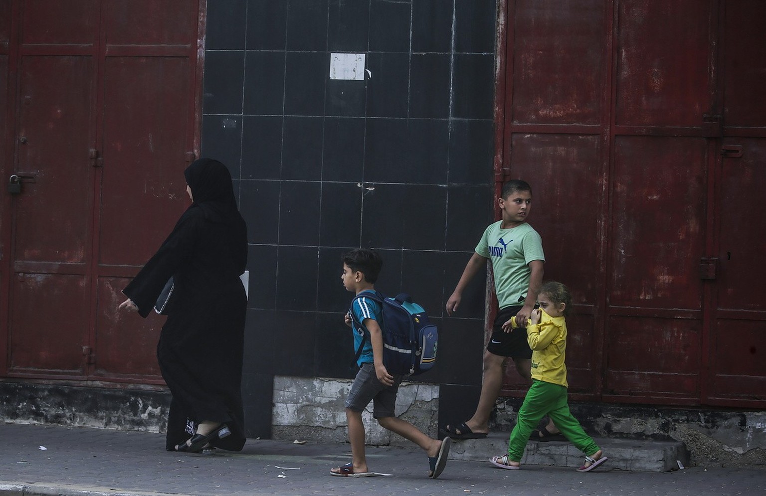 epa10915026 A Palestinian mother and her children flee from their house following an Israeli air strike in northern Gaza City, 12 October 2023. More than 1,400 Palestinians have been killed and over 6 ...