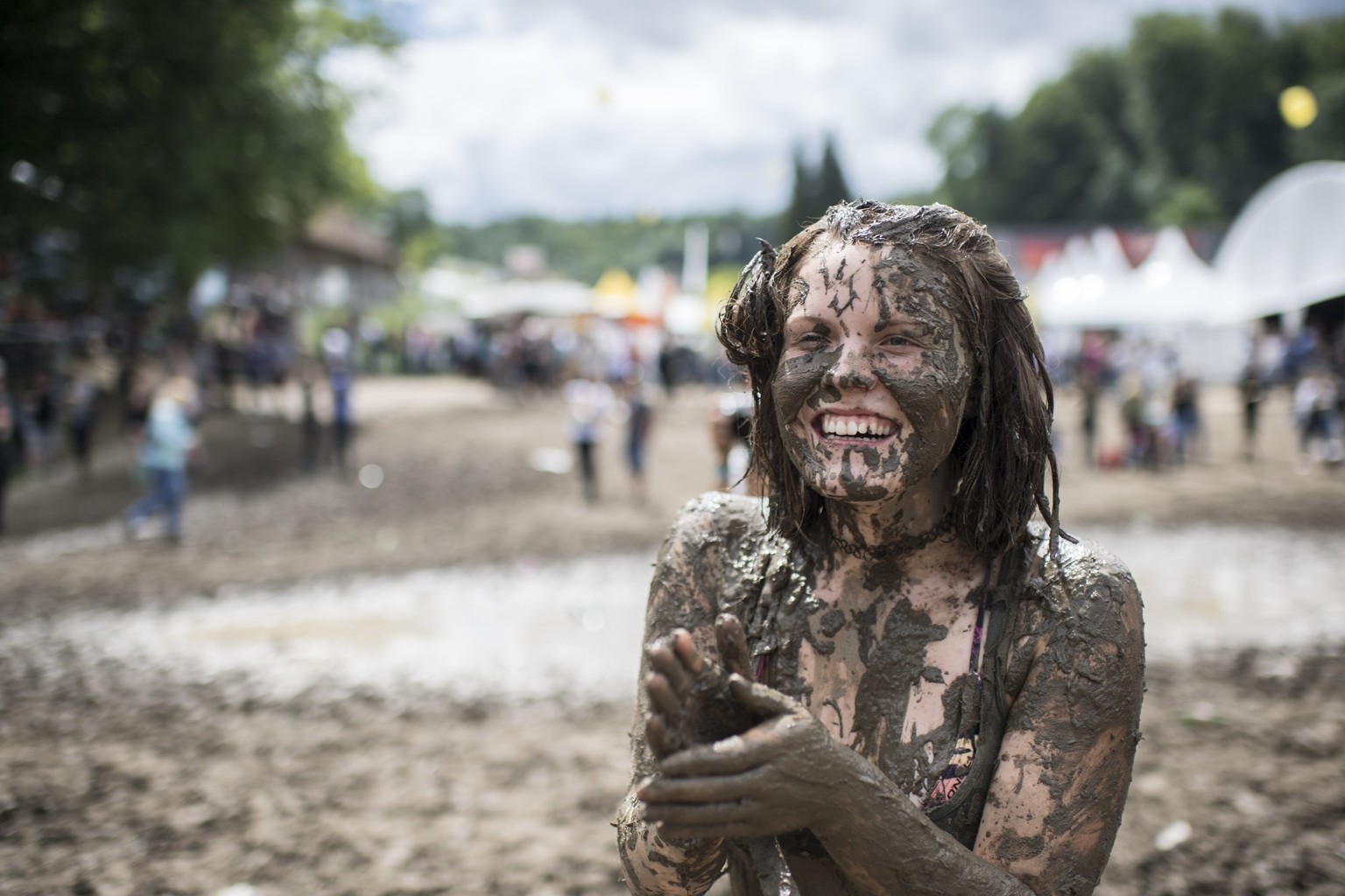 Visitors play in a puddle during the music festival Openair St. Gallen, on Saturday, July 1, 2017. The festival will take place until Sunday, July 2, 2017. (KEYSTONE/Ennio Leanza)