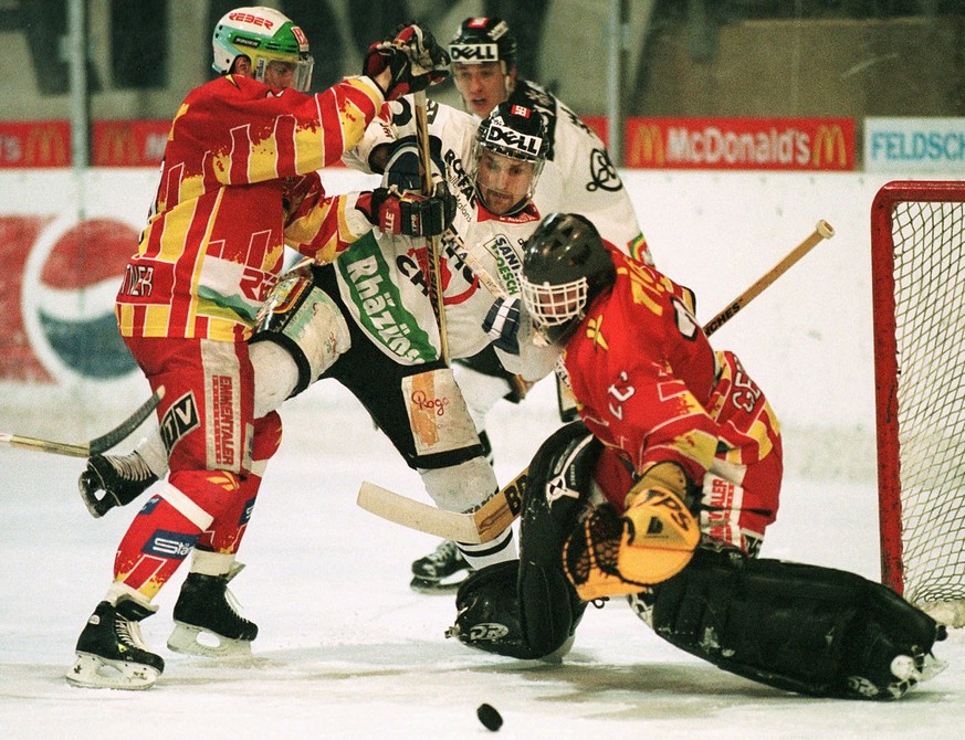 Die Churer Mario Brodmann (Mitte) und Harjis Witolins bleiben im Playoff Halbfinal der Nationalliga B vom Samstag, 28. Februar 1998, in Chur an den Langnauern Raoul Baumgartner und Goalie Martin Gerbe ...