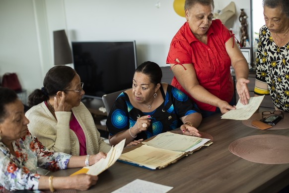 From left, Marie-Jose Loshi, Monique Bitu Bingi, Lea Tavares Mujinga, Simone Ngalula and Noelle Verbeeken speak with each other as they look over papers in Brussels, Belgium, on Monday, June 29, 2020. ...