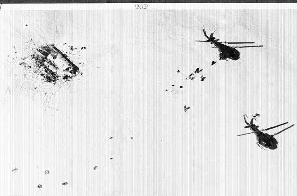 Survivors of the Uraguayan airplane that crashed in the Andes Mountains two months ago, walk toward helicopters during rescue operation, Dec. 23, 1972. At left, the wreck of the plane lies on the snow ...