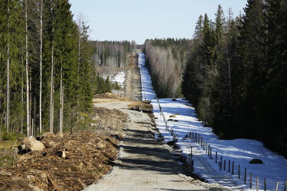 A border barrier fence between Finland, left, and Russia is seen in a forest near Pelkola border crossing point in Imatra, south-eastern Finland, Friday, April 14, 2023. (AP Photo/Sergei Grits)