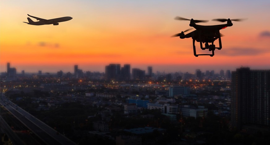 Flugzeug und Rohne über Stadt.