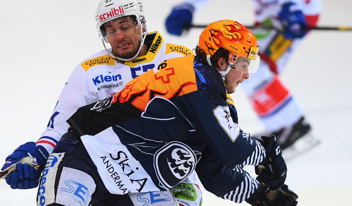 Kloten's player Lukas Stoop, left, fights for the puck with Ambri's player Dominic Zwerger, right, during the preliminary round game of National League Swiss Championship 2017/18 between HC  ...