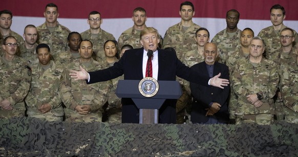 FILE - In this Nov. 28, 2019 file photo, President Donald Trump, center, with Afghan President Ashraf Ghani and Joint Chiefs Chairman Gen. Mark Milley, behind him at right, addresses members of the mi ...