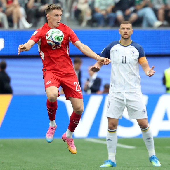 epa13047729 Michel Aebischer of Switzerland (L) and Edin Dzeko of Bosnia and Herzegovina in action during the FIFA World Cup 2026 group stage match Switzerland against Bosnia and Herzegovina, in Los A ...
