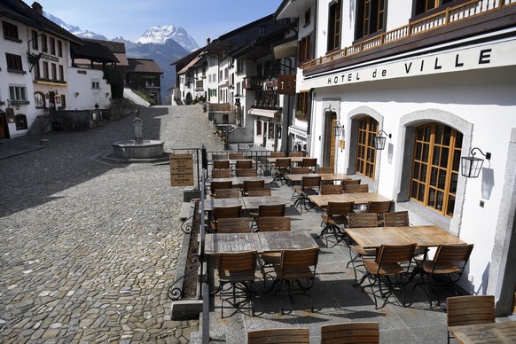 epa08326338 Restaurants and shops are closed in the empty main street of the medieval town of Gruyeres, in front of Le Moleson mountain during the state of emergency due to the coronavirus COVID-19 pa ...