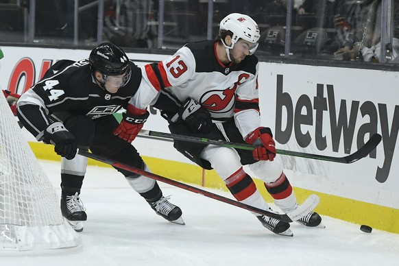Los Angeles Kings defenseman Mikey Anderson (44) and New Jersey Devils center Nico Hischier (13) vie for the puck during the first period of an NHL hockey game Friday, Nov. 5, 2021, in Los Angeles. (A ...