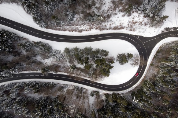 A car drives on the road of the &quot;Col du Mollendruz&quot; next to snow and frozen trees in the Jura Mountains, in Mont-la-Ville, Switzerland, Sunday, February 3, 2019. (KEYSTONE/Laurent Gillieron)