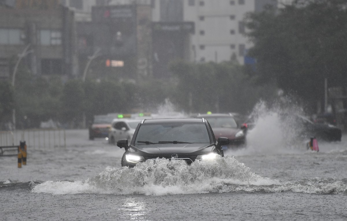 epa12249767 Vehicles drive through a flooded area in Haikou, Hainan Province, China, 20 July 2025. Typhoon Wipha, the sixth typhoon of the year, made landfall near Jiangmen City in south China's  ...