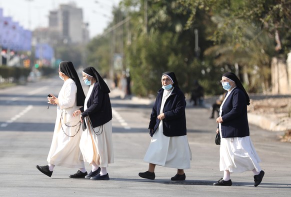 epa09053990 Nuns walk towards Our Lady of Delivrance church for a holy mass celebrated by Pope Francis in Baghdad, Iraq, 05 March 2021. Pope Francis started his three-day official visit Iraq, the firs ...
