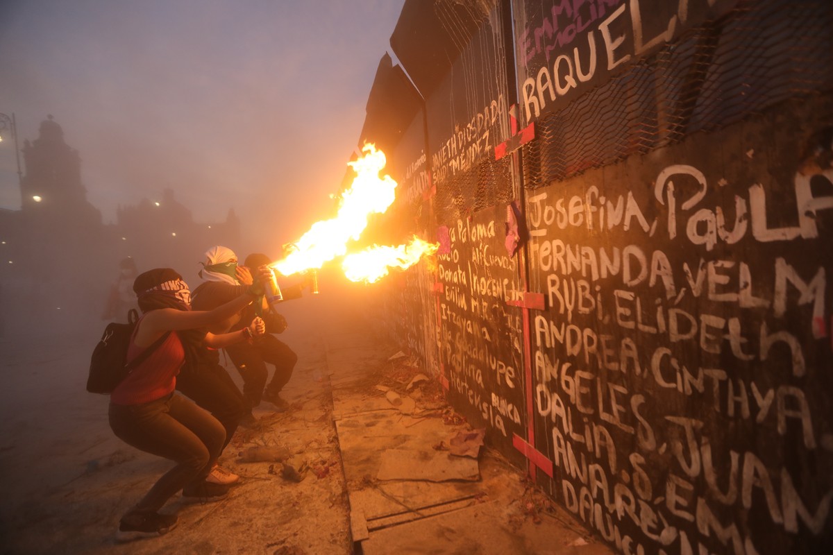 epa09063106 Activists in front of a wall erected at Plaza del Zocalo during a protest against the alarming numbers of femicides, on International Women's Day in Mexico City, Mexico, 08 March 2021 ...