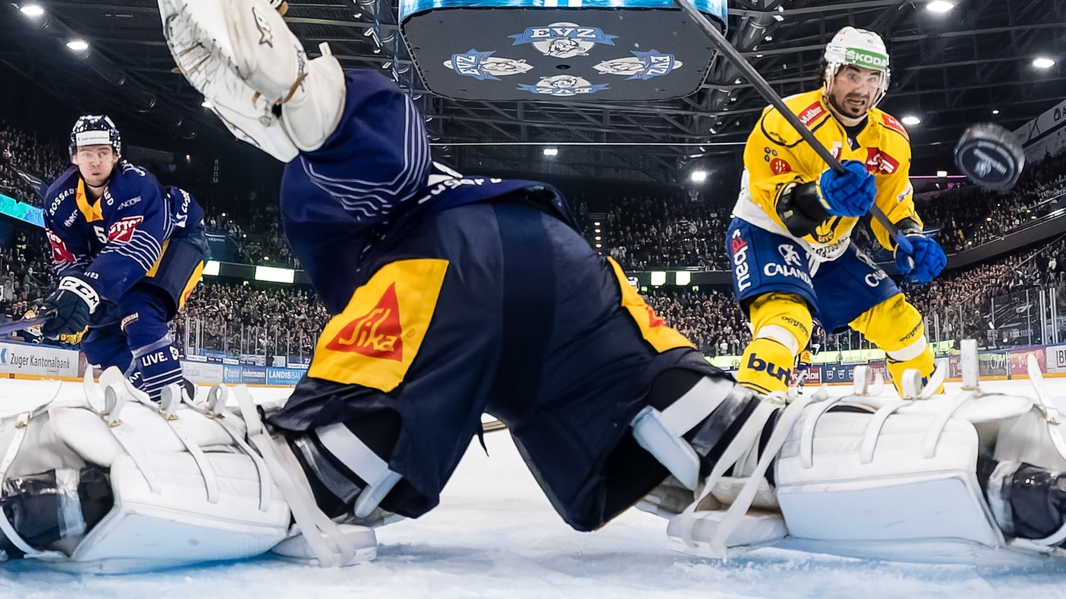 Davos Andres Ambuehl, rechts, erzielt das Tor zum 3:4 gegen Zugs Torhueter Leonardo Genoni im Eishockey Qualifikationsspiel der National League zwischen dem EV Zug und dem HC Davos am Samstag, 10. Dez ...