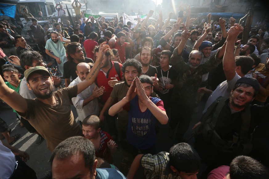 Rebel fighters and people carry the Free Syrian Army and Jabhat Fatah al-Sham flags as they celebrate the news of the breaking of the siege of rebel-held areas of Aleppo, Syria August 6, 2016. REUTERS ...