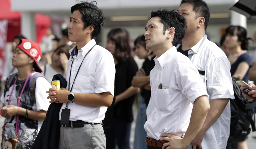 epa05464075 Pedestrians watch a large screen broadcasting Japanese Emperor Akihito's video message (unseen) on his thoughts, in Tokyo, Japan, 08 August 2016. Japanese Emperor Akihito expressed hi ...