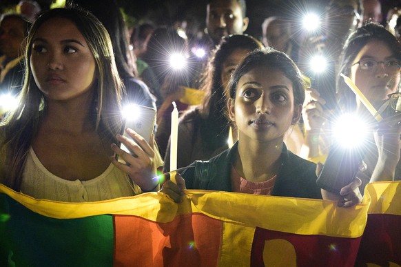 epa07529556 Members of the public join in an interfaith candlelight vigil during a Mass of Remembrance for the victims of the Easter Sunday bombings in Sri Lanka, at St Mary&#039;s Cathedral, Sydney,  ...