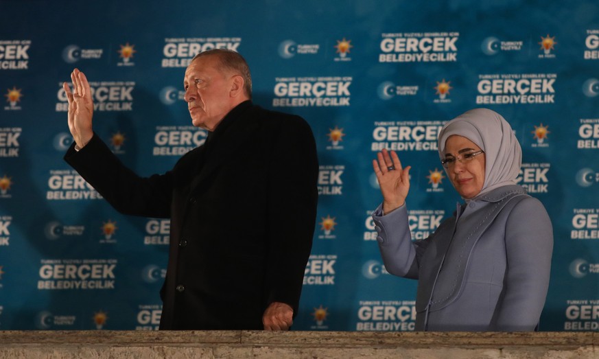 epa11254034 Turkish President Recep Tayyip Erdogan (L) and his wife Emine greet supporters after the polls closed in the local elections in Ankara, Turkey, 31 March 2024. Some 61 million people voted  ...