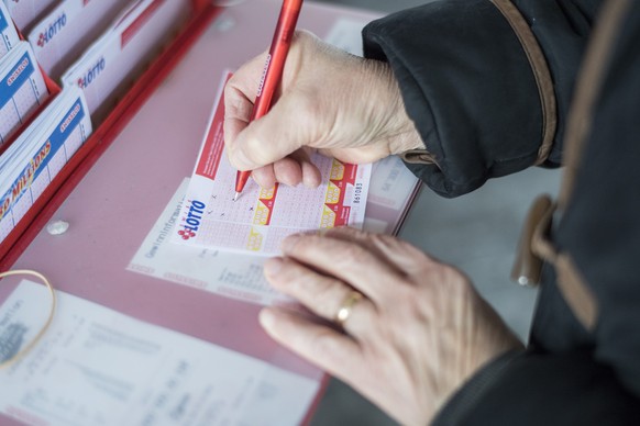 Eine Frau fuellt ein Los mit dem aktuellen Swiss Lotto Gewinn von 64.3 Millionen Franken aus, aufgenommen am Mittwoch 14. Dezember 2016, in Brugg. (KEYSTONE/Ennio Leanza)