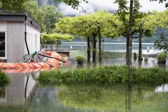 Die Uferpromenade ist ueberschwemmt, am Donnerstag, 14. Juli 2021, in Neuhaus bei Interlaken. Nach den intensiven Regenfaellen der letzten Tagen werden die Ufer zum Teil ueberschwemmt. (KEYSTONE/Peter ...