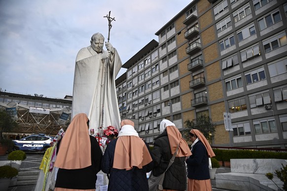 epa11949748 Nuns pray in front of a statue of John Paul II at the entrance of Gemelli hospital where Pope Francis is still hospitalized, in Rome, Italy, 08 March 2025. Pope Francis was admitted to Rom ...