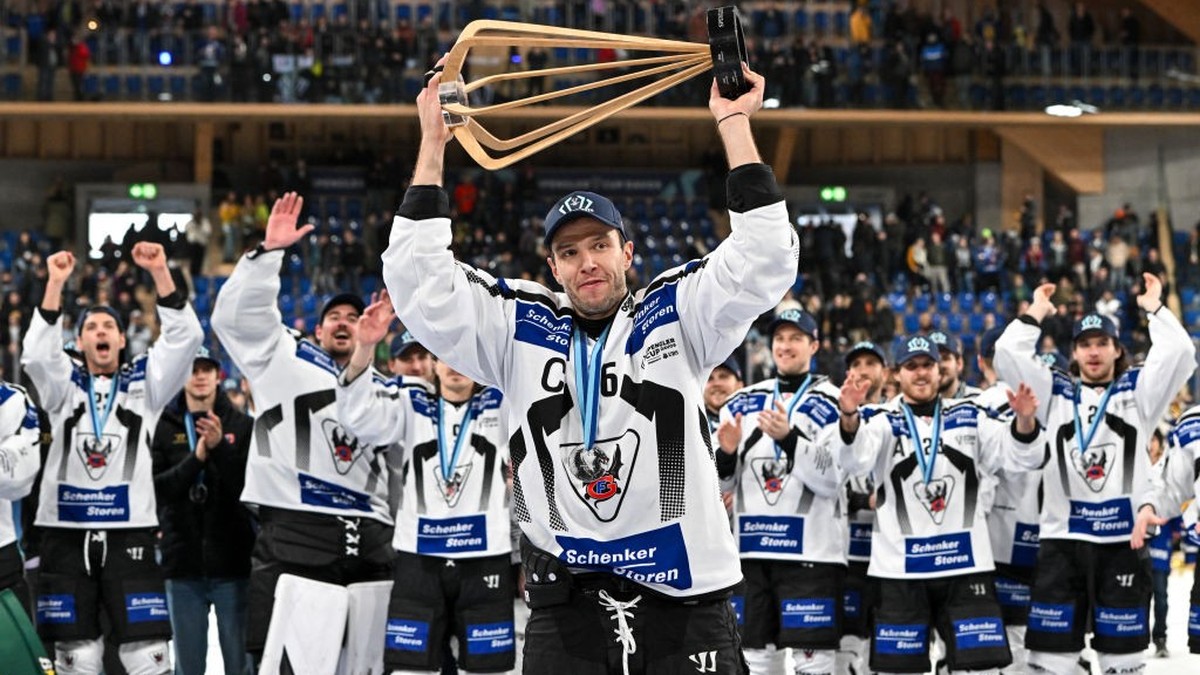 DAVOS, SWITZERLAND - DECEMBER 31: Julien Sprunger of HC Fribourg-Gotteron raises the trophy after winning the Spengler Cup Davos final match between Straubing Tigers and Fribourg-Gottéron at Eisstadio ...