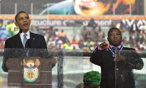 FILE - In this file photo from Dec.10, 2013, Thamsanqa Jantjie, right, interprets in sign language for President Barack Obama during his remarks at a memorial service at FNB Stadium in honor of Nelson ...