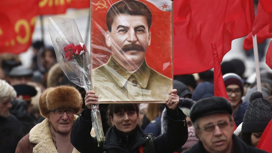 epa05684241 Communist party members and supporters carry late Joseph Stalin&#039;s portraits and flowers as they walk in the Red Square in Moscow, Russia, 21 December 2016, to pay a visit to the Sovie ...