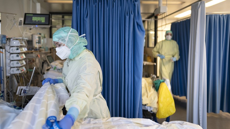 Aerzte und Pflegende kuemmern sich um Covid-Patienten auf der Covid-19-Intensivabteilung im Stadtspital Triemli am 10. Dezember 2020 in Zuerich. (KEYSTONE/Gaetan Bally)