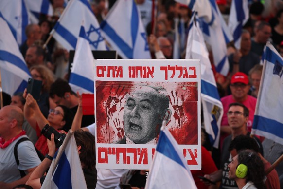 epa11333505 A person holds a placard depicting Israeli Prime Minister Netanyahu and reading &quot;because of you we are dead&quot; during a protest calling for the release of hostages held by Hamas in ...