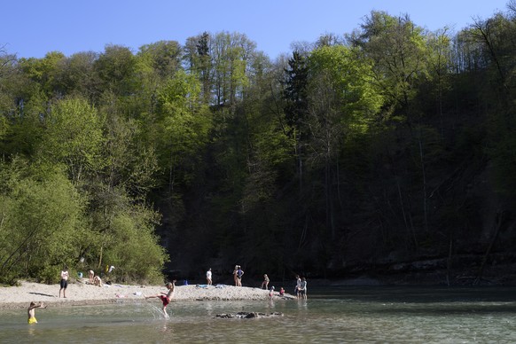 People enjoy the sunny weather next to the Aare river, at Bremgarten bei Bern, Switzerland, on Thursday, April 19, 2018. (KEYSTONE/Anthony Anex)
