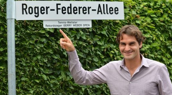 Fühlt sich in Halle pudelwohl: Roger Federer mit dem Schild seiner Allee.