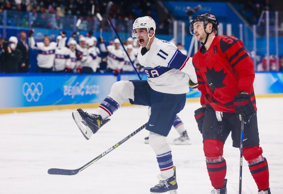 epa09748603 Kenny Agostino (L) of USA celebrates scoring a goal during the Men&#039;s Ice Hockey preliminary round match between Canada and United States at the Beijing 2022 Olympic Games, Beijing, Ch ...