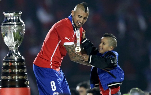 Muss sich wohlfühlen: Arturo Vidal mit Pokal links und Sohn rechts.
