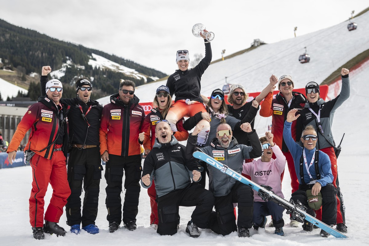 Lara Gut-Behrami of Switzerland and team celebrate with the women's giant slalom overall leader crystal globe trophy in the finish area during the second run of the women's giant slalom race ...