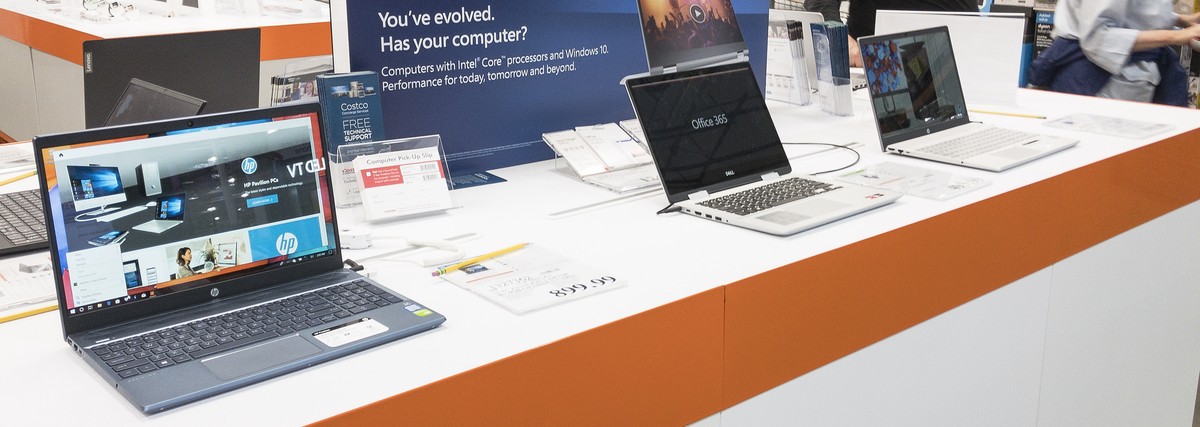 epa07771839 Customers pass by laptops on display at a Costco Club store in Waltham, Massachusetts, USA 13 August 2019. Earlier oil the day United States President Donald J Trump announced the exemptio ...