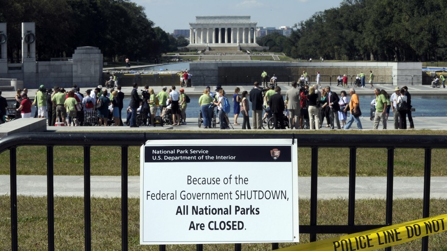 FILE - In this Oct. 2, 2013 file photo, despite signs stating that the national parks are closed, people visit the World War II Memorial in Washington. No government shutdown this year, Republican con ...