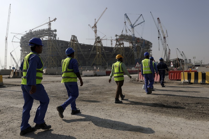 FILE - Workers walk to the Lusail Stadium, one of the 2022 World Cup stadiums, in Lusail, Qatar, Friday, Dec. 20, 2019. The eight stadiums for the World Cup, all within a 30-mile radius of Doha, are n ...