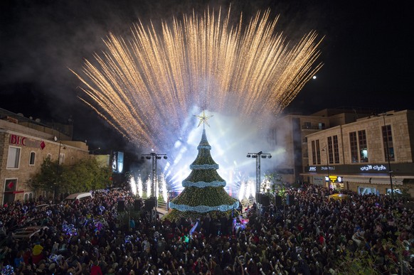 epa10355549 People gather around a giant Christmas tree, which has been officially lit up at the entrance of Byblos (Jbeil), Lebanon, 08 December 2022. EPA/WAEL HAMZEH