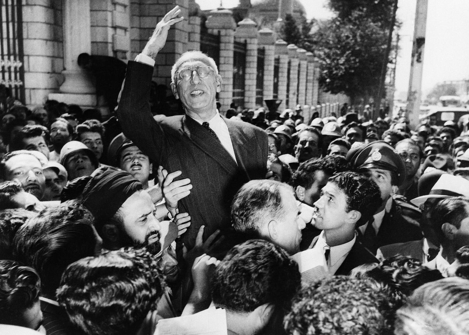 FILE - In this Sept. 27, 1951 file photo, Iranian Prime Minister Mohammad Mossadegh rides on the shoulders of cheering crowds in Tehran's Majlis Square, outside the parliament building, after rei ...