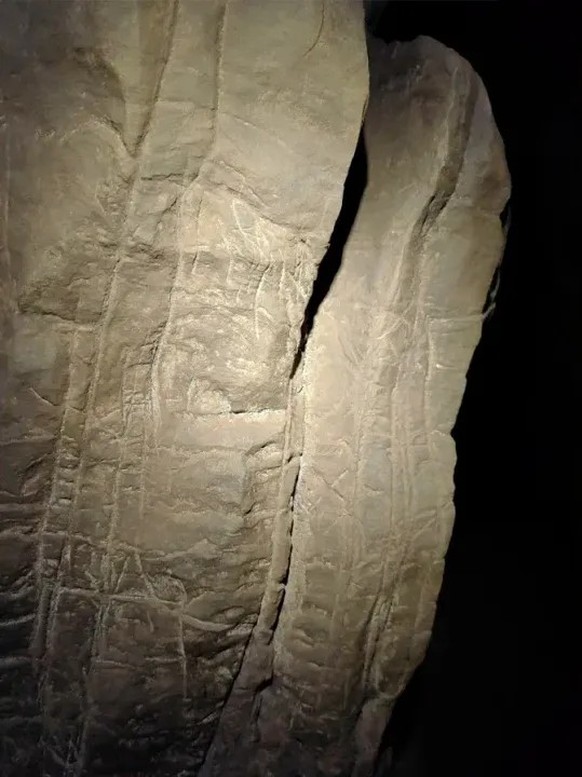A wall of the Hill Antechamber showcases numerous engravings and etchings. The panel shows repeated etchings of squares, ladders, triangles, crosses and X&#039;s.