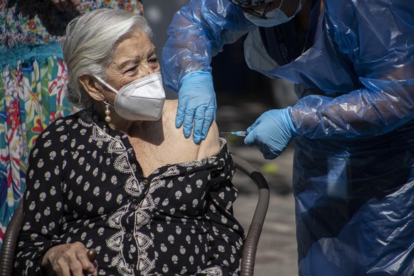 Alicia Martinez gets her second dose of China&#039;s Sinovac COVID-19 vaccine in the outdoor patio of a home for the elderly in Santiago, Chile, Friday, March 5, 2021. (AP Photo/Esteban Felix)