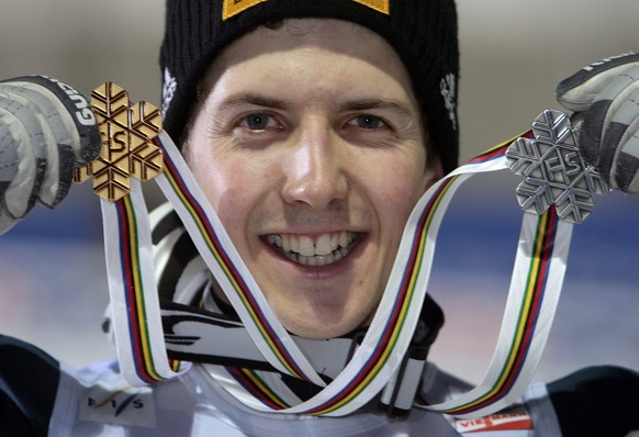 Swiss Ski Jumper Simon Ammann shows his gold medal he won last Saturday and his silver medal he won today on the normal hill individual ski jumping final of the Nordic Ski World Championships at Miyan ...