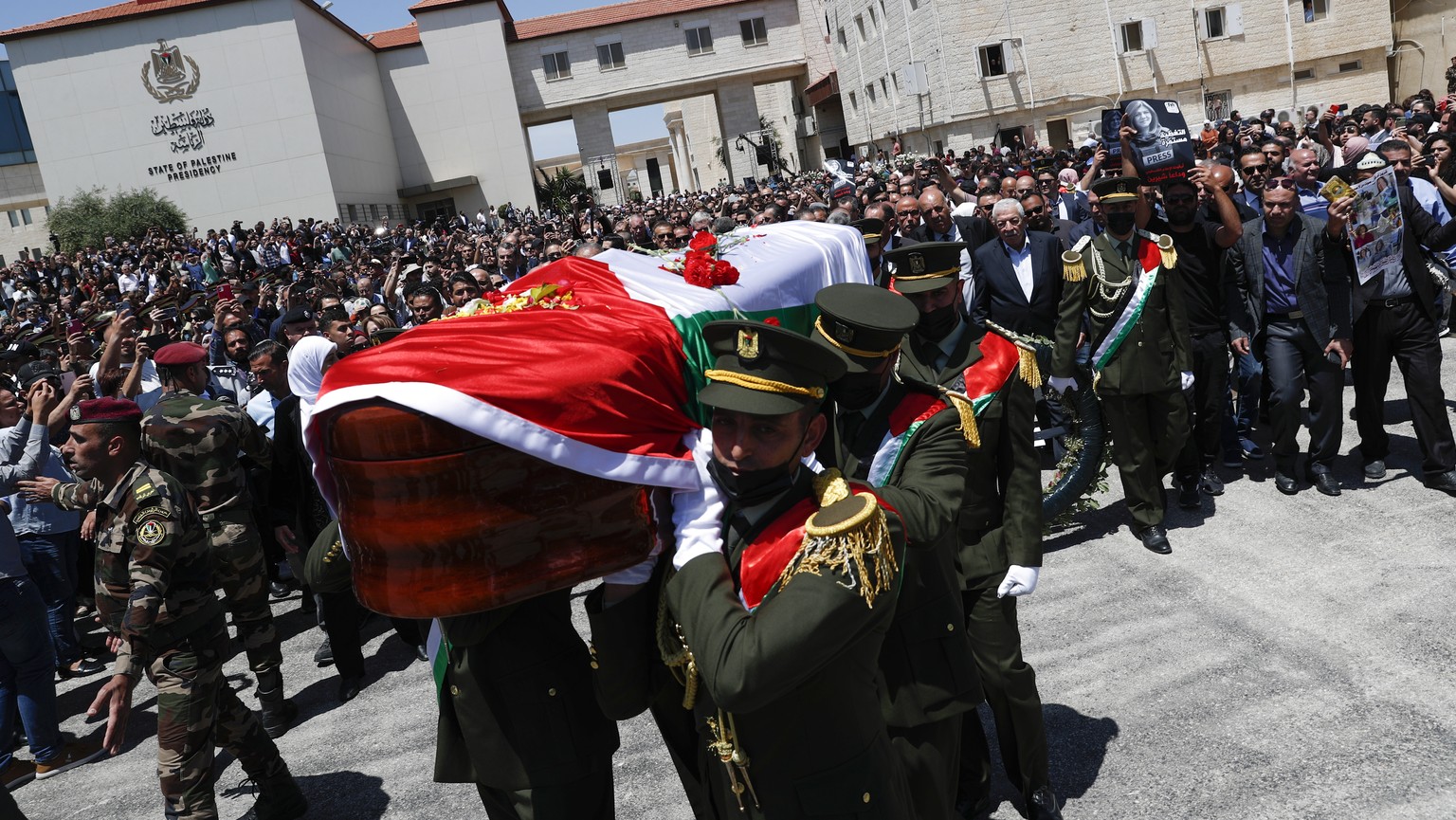 epa09941917 Palestinian honor guard carry the coffin of Al-Jazeera correspondent Shireen Abu Akleh during an official funeral at the headquarters of the Palestinian Authority in the West Bank city of  ...