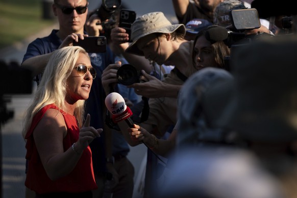 Rep. Marjorie Taylor Greene, R-Ga., talks to a journalist after walking out of the Fulton County Jail parking lot in Atlanta on Thursday, Aug. 24, 2023. (AP Photo/Ben Gray)
