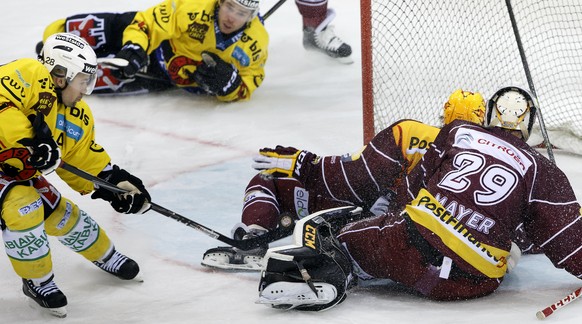 Martin Plüss (links) schiebt den Puck an Servette-Goalie Robert Mayer vorbei zum 4:3 ins Tor.