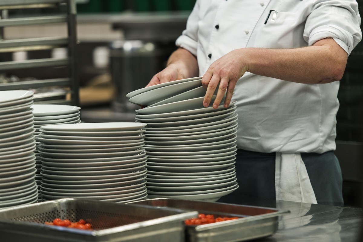 An employee handles plates in the kitchen, pictured during a look behind the scenes at Hotel Seedamm Plaza in Pfaeffikon, canton of Schwyz, Switzerland, on March 31, 2014. (KEYSTONE/Christian Beutler) ...