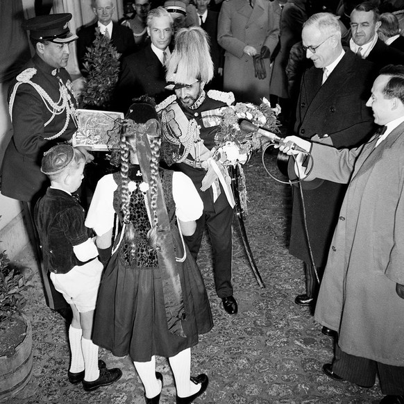 Ein Trachtenmädchen und ein Bub im Kühermutz überreichen dem Kaiser einen Lebkuchen. Als Gegengeschenk erhalten sie vom Kaiser Münzen.
https://permalink.nationalmuseum.ch/100664430