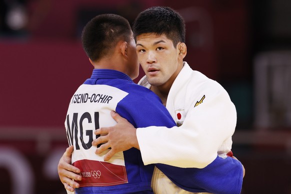 epa09366907 Tsogtbaatar Tsend-Ochir (blue) of Mongolia hugs Shohei Ono (white) of Japan in congratulations on his win during their bout in the Men&#039;s Judo -73kg Semifinal of Table A at the Tokyo 2 ...