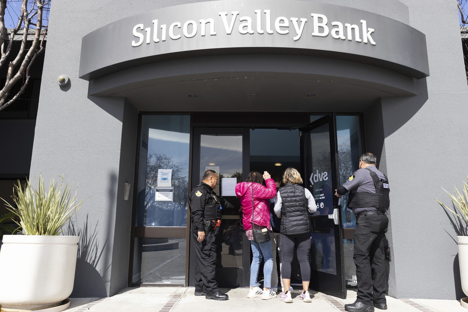 Security guards let individuals enter the Silicon Valley Bank&#039;s headquarters in Santa Clara, Calif., on Monday, March 13, 2023. The federal government intervened Sunday to secure funds for deposi ...